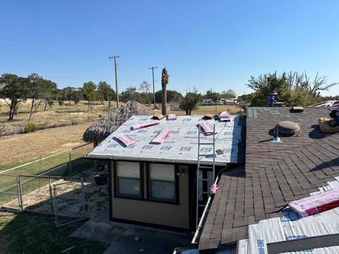 Roofers repairing storm damaged roof. 