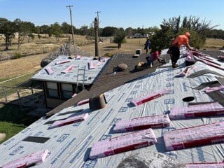 Roofers repairing storm damaged roof. 