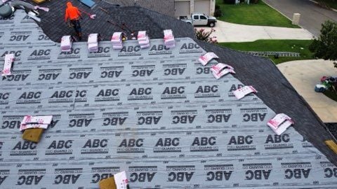 Roofers repairing storm damaged roof. 