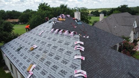 Roofers repairing storm damaged roof. 