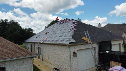 Roofers repairing storm damaged roof. 