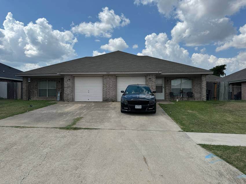 Home with two car garage and grey shingle roof.